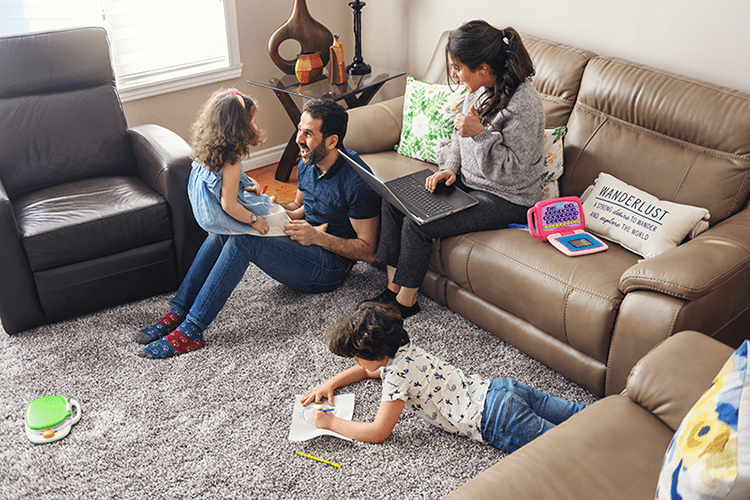 A family sits in a living room. The Basics of Winter Indoor Air Quality.