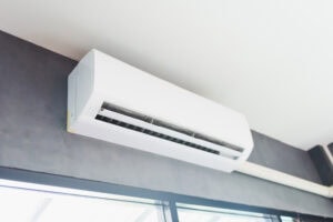 How Much Does it Cost to Install a Ductless Mini Split? Cool air conditioner swing system on wall in room.