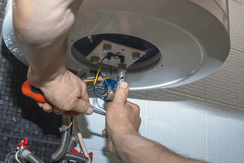 Image of someone repairing a furnace. What Are Signs I Need a New Furnace?